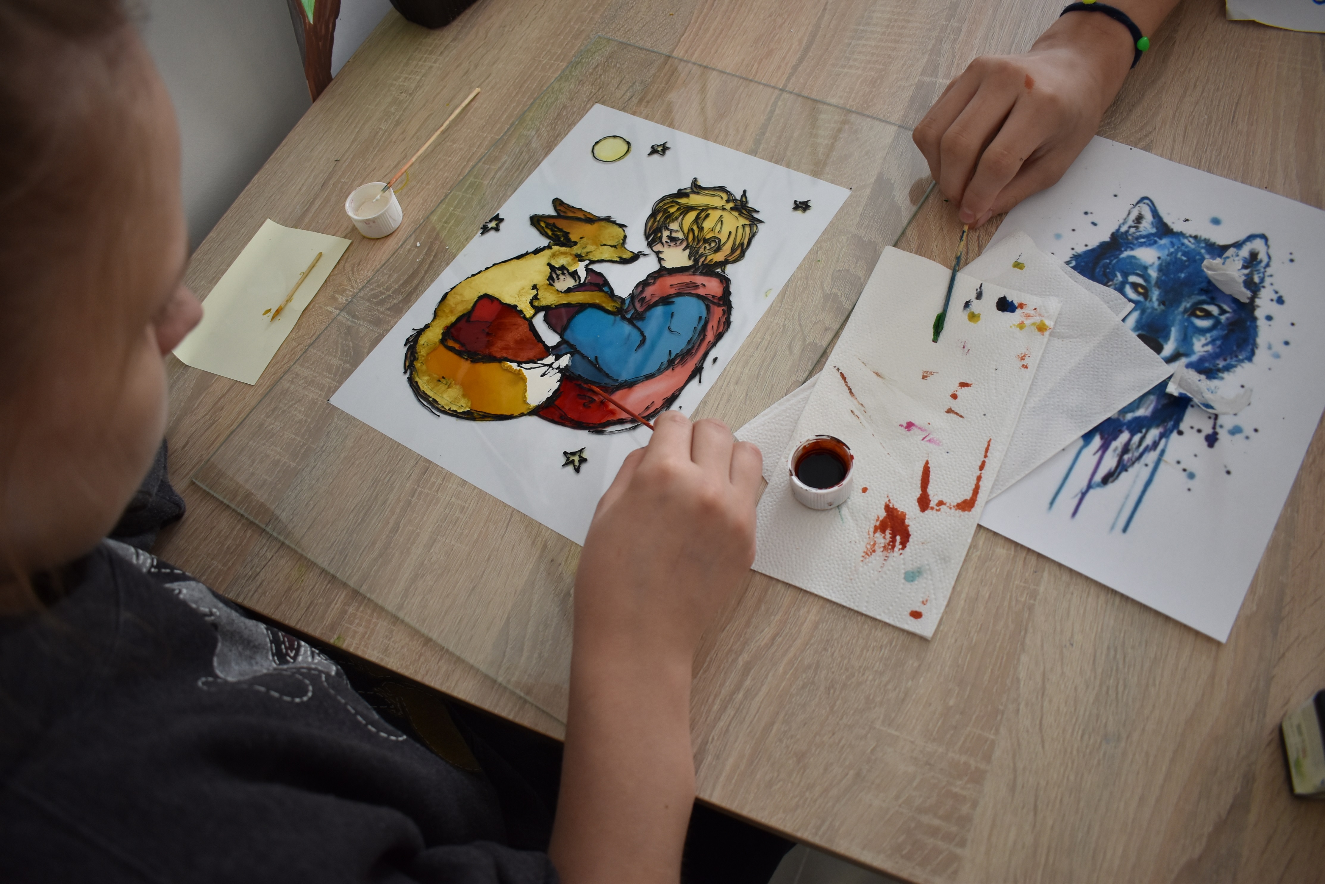 Dziecko maluje farbami na szkle