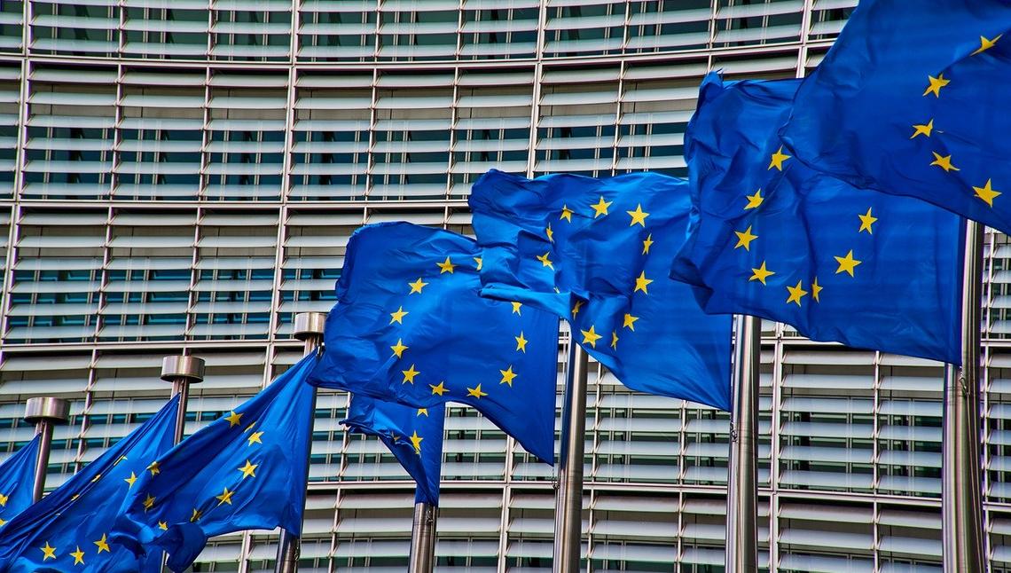 Flagi Unii Europejskiej na tle siedziby Komisji Europejskiej