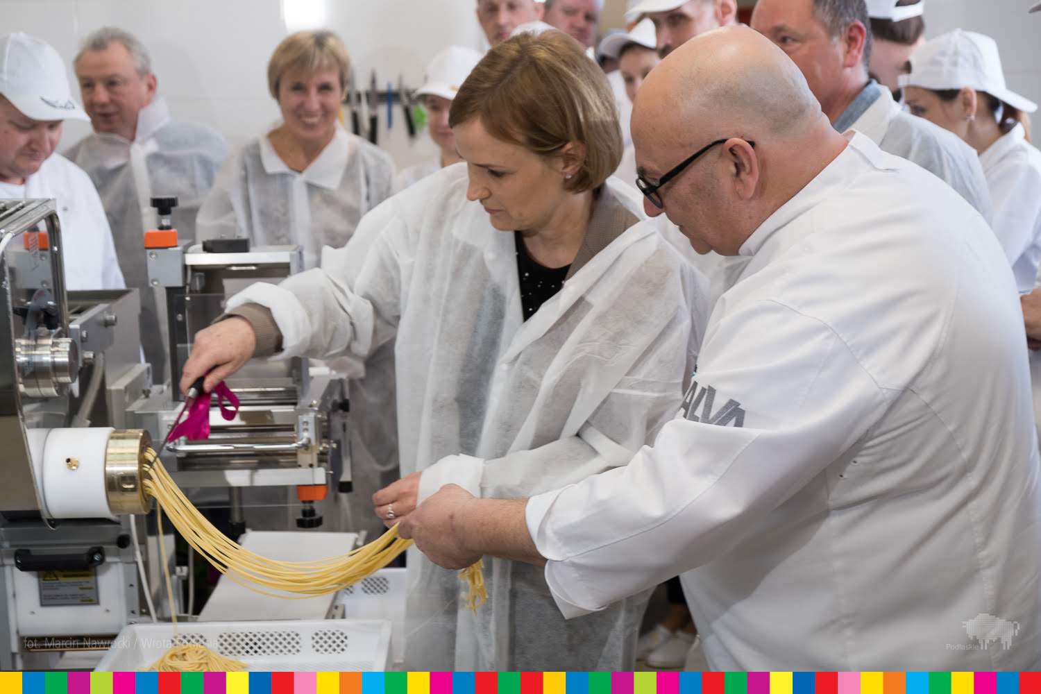 Dyrektor Departamentu EFS Elżbieta Romańczuk wraz z kucharzem stoją przed maszyną do produkcji makaronu. 