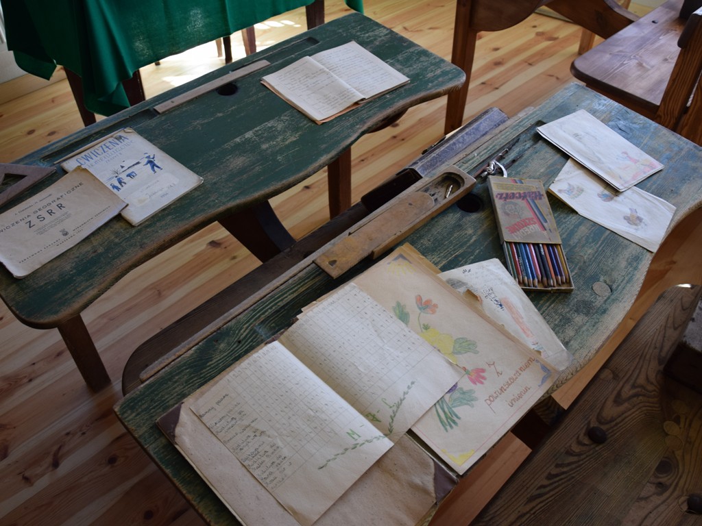 Zbliżenie na ławkę szkolną i eksponaty ze szkoły z Kalinowa. 