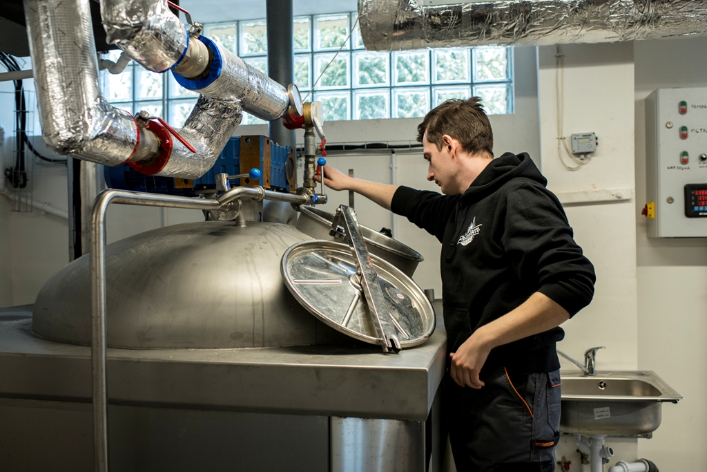 Pracownik mini browaru sprawdza proces produkcji piwa.