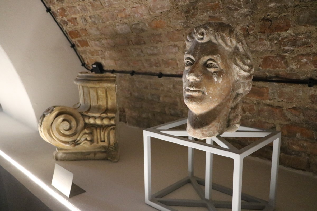 Eksponaty na wystawie, rzeźba głowy i fragment cokołu