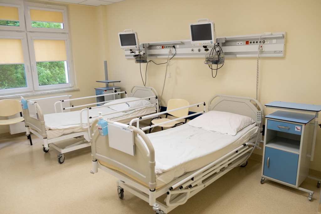 Sala szpitalna z dwoma lóżkami i panelem urządzeń medycznych do monitorowania stanu pacjenta