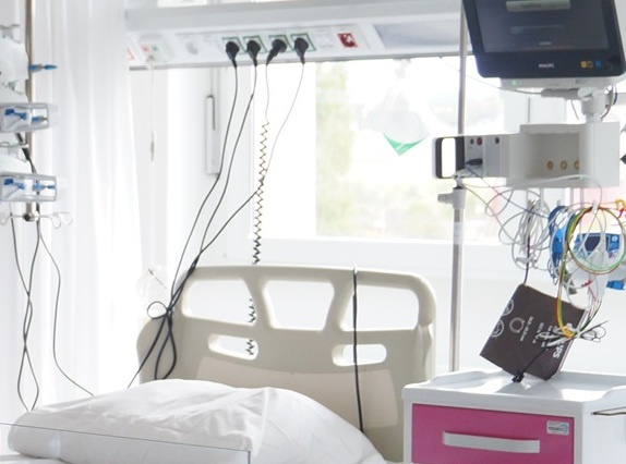 Szpitalne łóżko i monitory / Hospital bed, next to it equipment and monitors